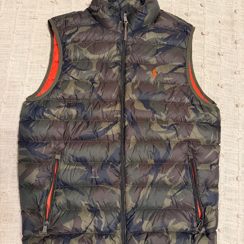 The Polo Ralph Lauren Camo/Orange Puffer Vest is a stylish and practical outerw